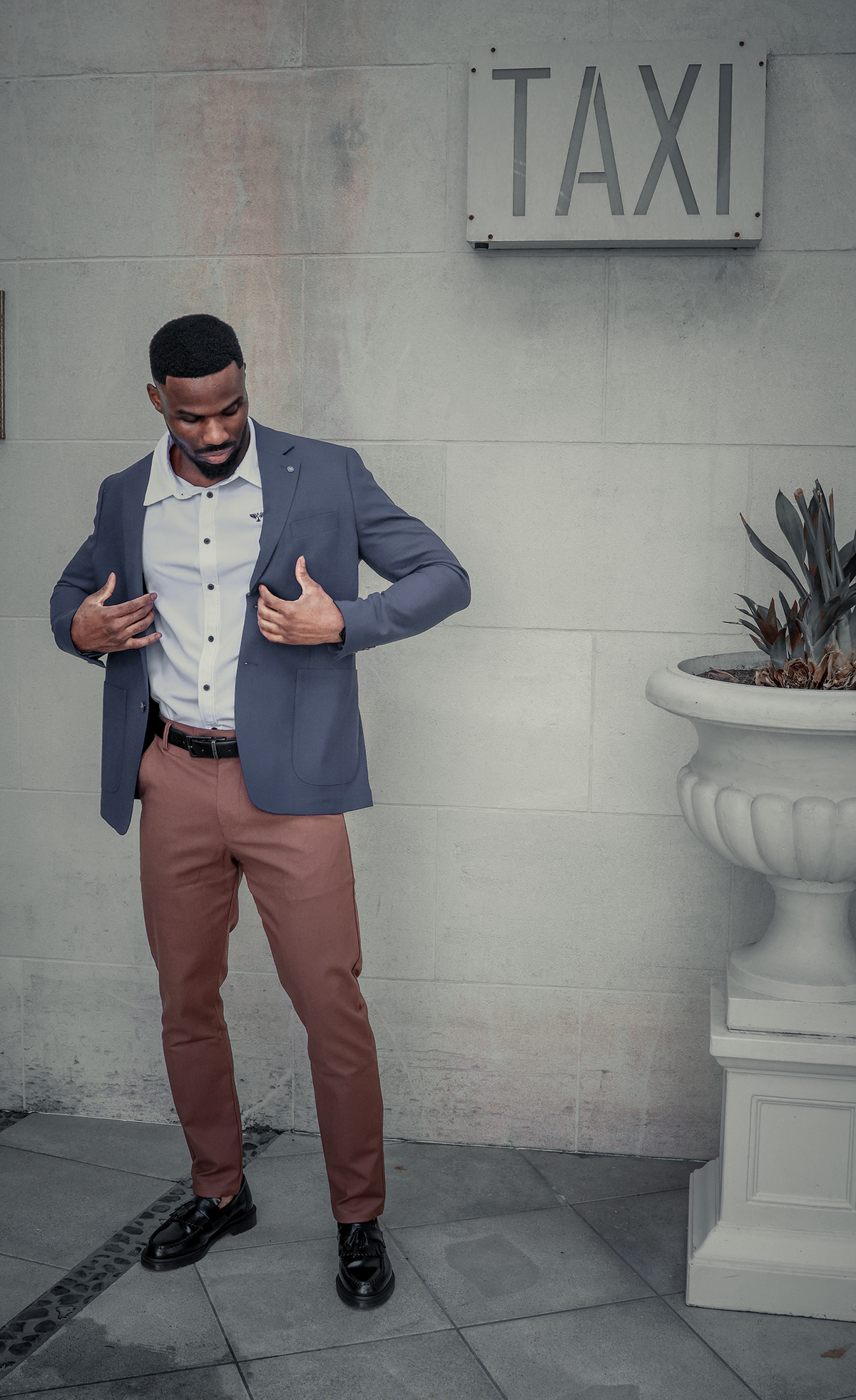 Man seated wearing a navy blazer and brown Signore Chino